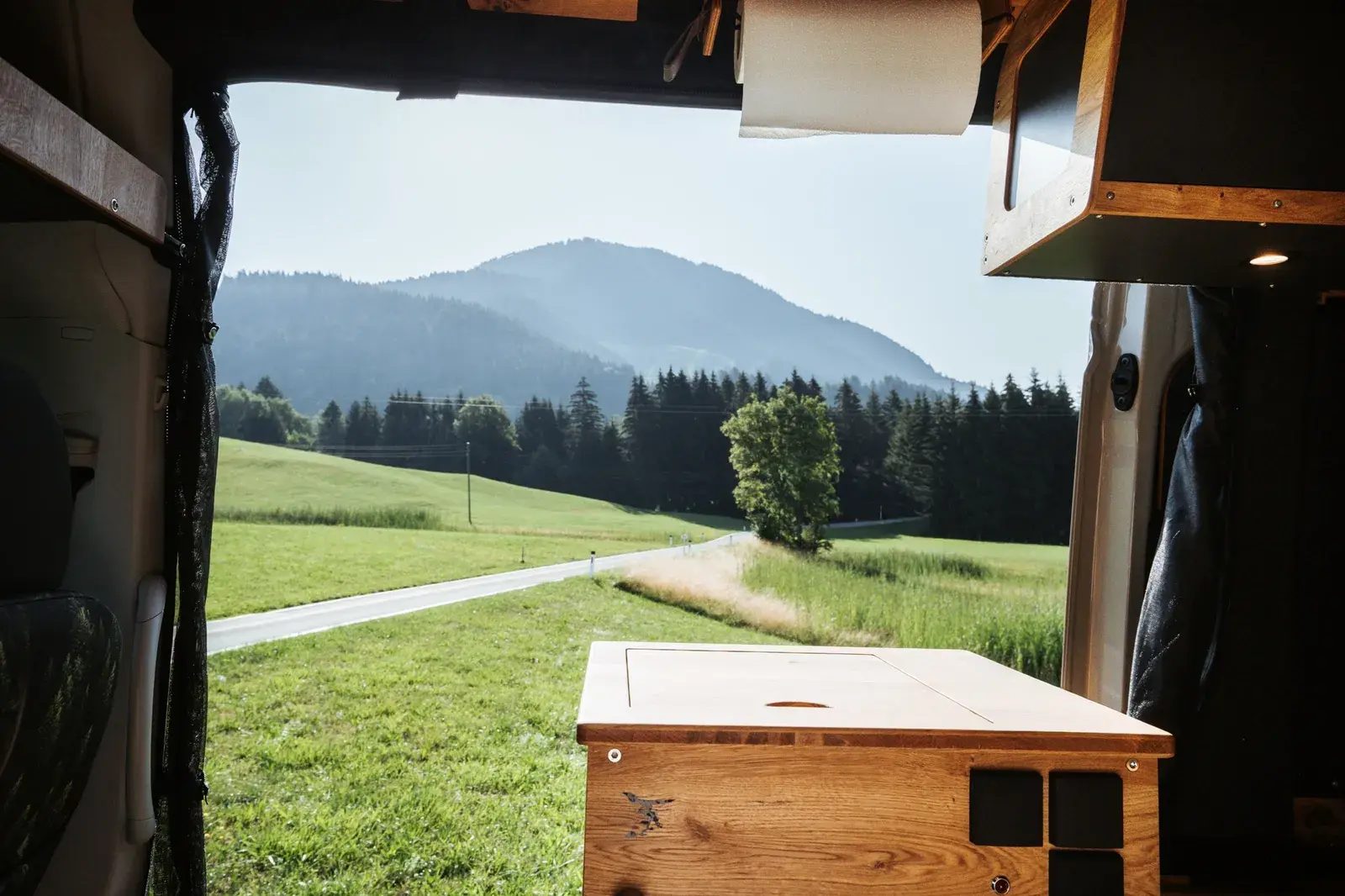 Blick aus der offenen Schiebetür des Castello über den Küchenblock auf Wiesen und Berge