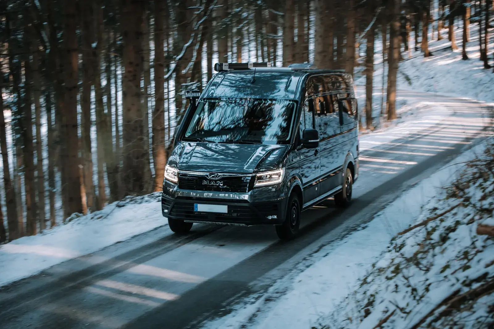 Castello Camper auf verschneiter Waldstraße unterwegs