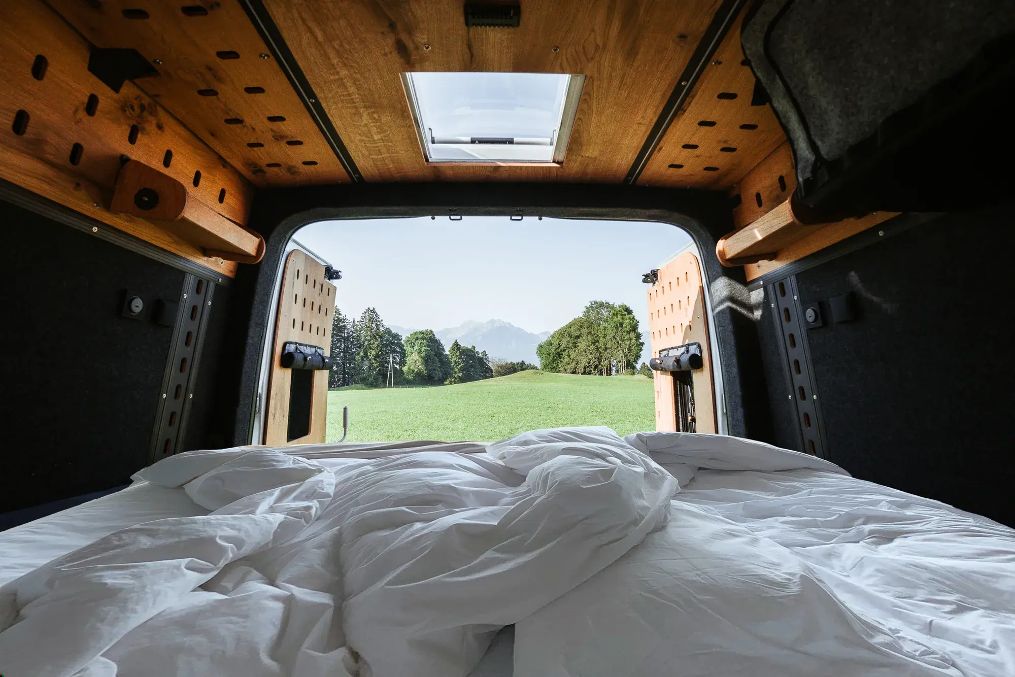 Blick vom Bett im Castello durch die offenen Hecktüren in die Natur