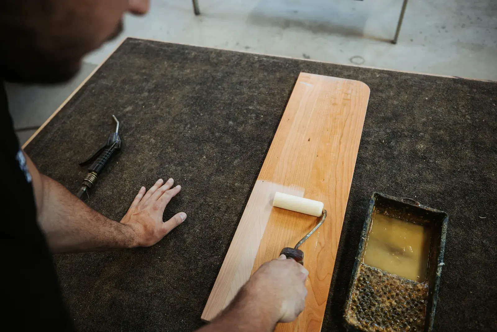 Holzplatte wird in der Werkstatt mit der Rolle geölt